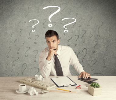 İş adamı soru işaretiyle masada.