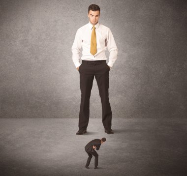 Büyük iş adamı küçük işçilere bakıyor.