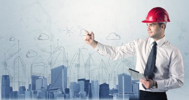 Genç işçi şehir manzarası çiziyor.