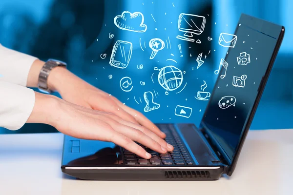 Hand writing on notebook computer with media icons — Stock Photo, Image