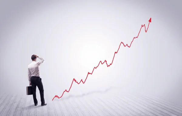 Empresário de pé com seta de gráfico vermelho — Fotografia de Stock