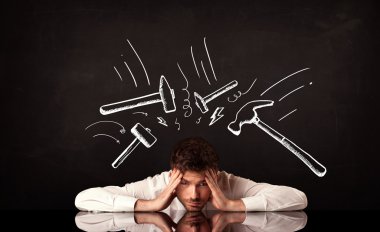 Depresyondaki işadamı çekiç izlerinin altında oturuyor