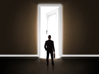 Büyük parlak kapıyı açan bir iş adamı.