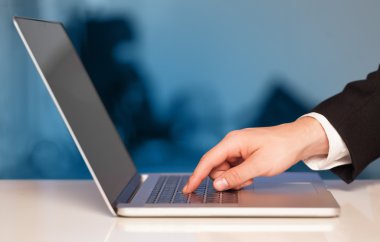 modern dizüstü bilgisayar üzerinde renkli backgrou basarak işadamı