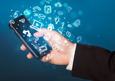 Medya simgeleri ve sembolleriyle el ele tutuşan akıllı telefon 