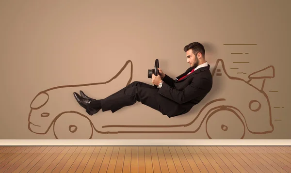 Happy man driving an hand drawn car on the wall — Stock Photo, Image