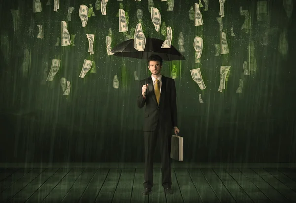 Бизнесмен, стоящий с зонтиком в долларовой концепции купюры дождь — стоковое фото