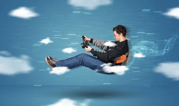 Funny racedriver young man driving between clouds concept — Stock Photo, Image