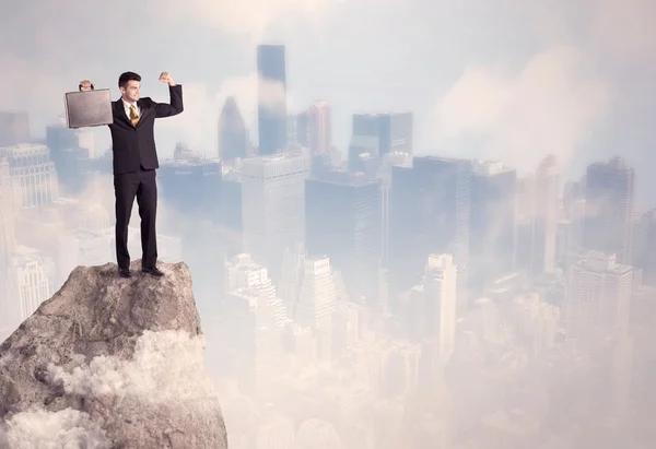 Winnaar stedelijke zakenman op de top van steen — Stockfoto