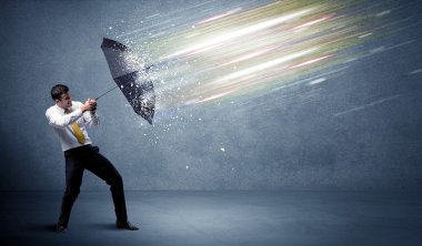 Şemsiye konseptiyle ışık demetlerini savunan iş adamı