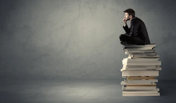 Stilvolles Männchen sitzt auf Büchern — Stockfoto