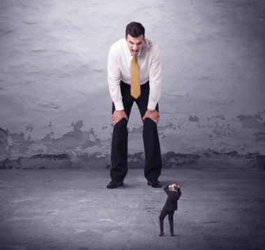 Kızgın büyük müdür küçük iş adamına bakıyor.