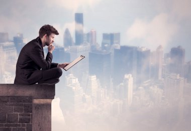 Yüksek bir binanın tepesinde oturan satıcı.