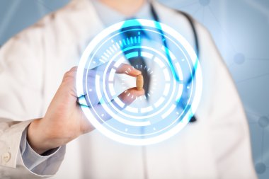 Erkek doktor elinde parlak halkaları olan bir hap tutuyor.