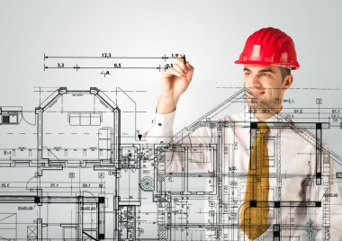 Genç bir mimar ev planı çiziyor.