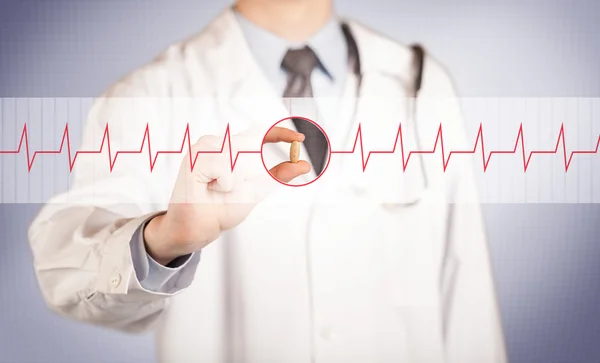 A doctor  holding a heart pill — Stock Photo, Image