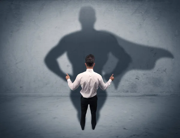 Successful businessman with superhero shadow