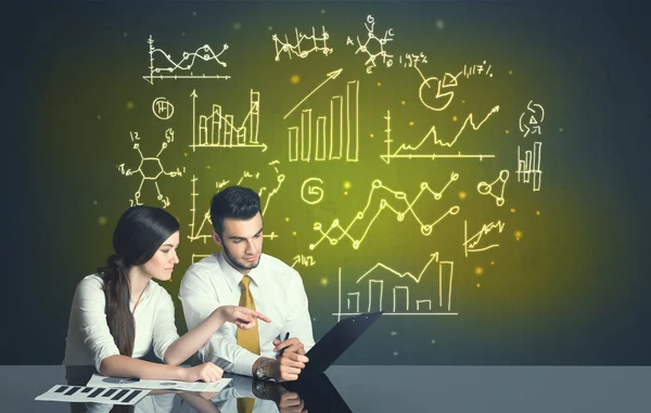 Business couple with business diagrams — Stock Photo, Image