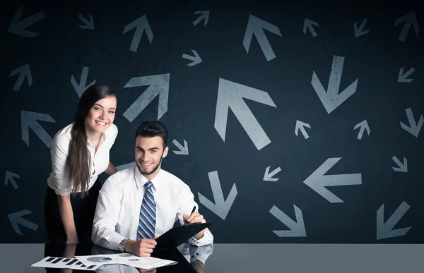 Business couple with arrows in background — Stock Photo, Image