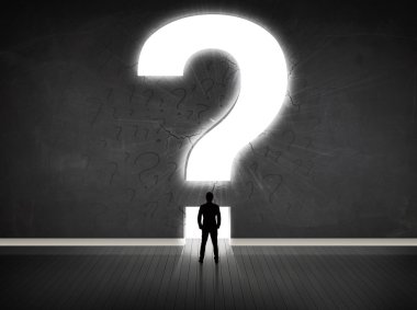 Parlak bir soru işaretiyle duvara bakan bir iş adamı 