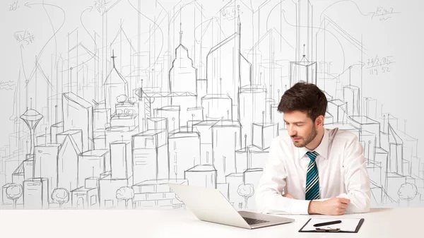 Businessman sitting at the white table with hand drawn buildings — Stock Photo, Image