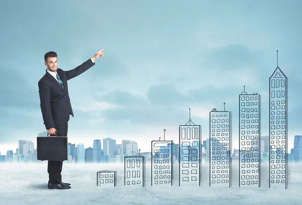 Ділова людина піднімається на руки намальовані будівлі в місті — стокове фото