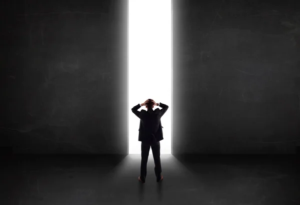 Persona de negocios mirando a la pared con apertura de túnel de luz —  Fotos de Stock