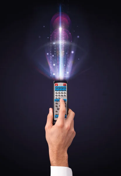 Hand with remote control and shining numbers — Stock Photo, Image