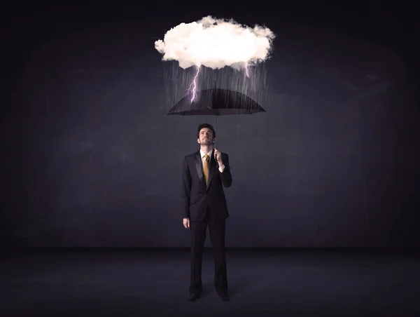 Businessman standing with umbrella and little storm cloud — Stock Photo, Image