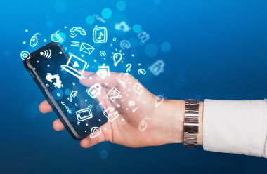 Medya simgeleri ve sembolleriyle el ele tutuşan akıllı telefon 