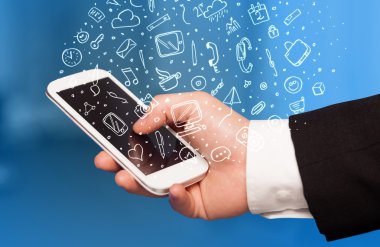 Elle çizilmiş medya simgeleri ve sembolleri ile akıllı telefonu tutmak