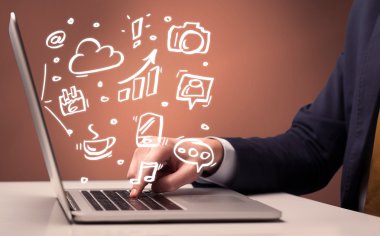 Ofis çalışanı dizüstü bilgisayarın önünde oturuyor.