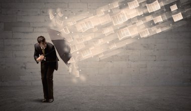 İş adamı ile şemsiye kağıtları rüzgara karşı koruma