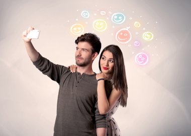 Mutlu çift gülen yüzle selfie çekiyor.