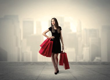 Kırmızı alışveriş çantalı zarif şehir kızı.