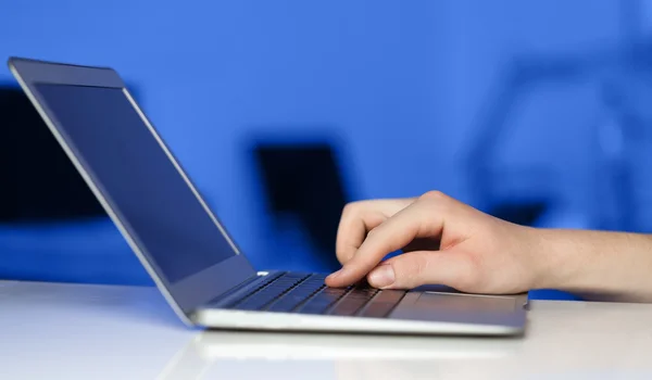 Empresário pressionando computador portátil moderno em backgrou colorido — Fotografia de Stock