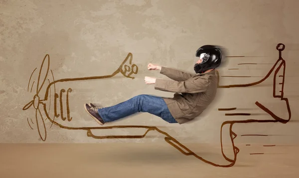 Funny pilot driving a hand drawn airplane on the wall — Stock Photo, Image