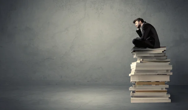 Elegante macho sentado en los libros —  Fotos de Stock