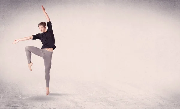 Moderne Balletttänzerin führt Kunstsprung mit leerem Hintergrund auf — Stockfoto