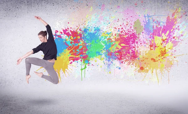 Dançarina de rua moderna pulando com respingos de tinta coloridos — Fotografia de Stock