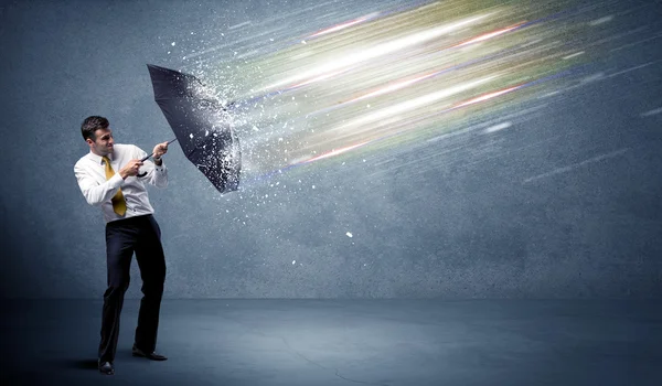 Homem de negócios defendendo feixes de luz com conceito guarda-chuva — Fotografia de Stock