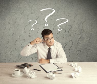İş adamı soru işaretiyle masada.