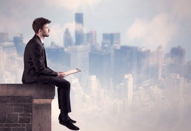 Yüksek bir binanın tepesinde oturan satıcı.