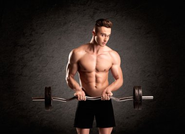 Seksi halterci adam kaslarını gösteriyor.