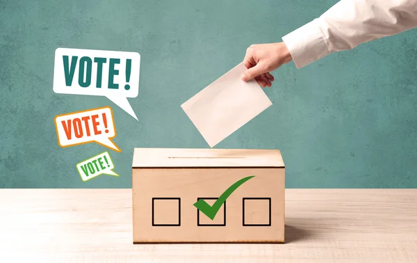 Placing a voting slip into a ballot box — Stock Photo, Image