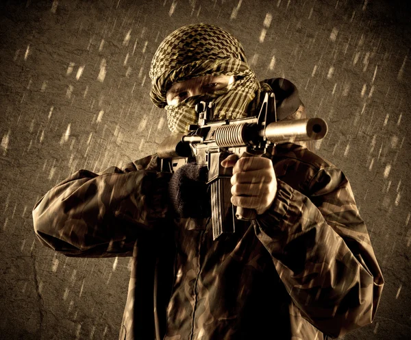 Dangerous heavily armed terrorist soldier with mask on grungy ra — Stock Photo, Image
