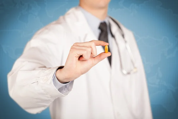 Γιατρός στα λευκά κρατώντας ένα χάπι — Φωτογραφία Αρχείου