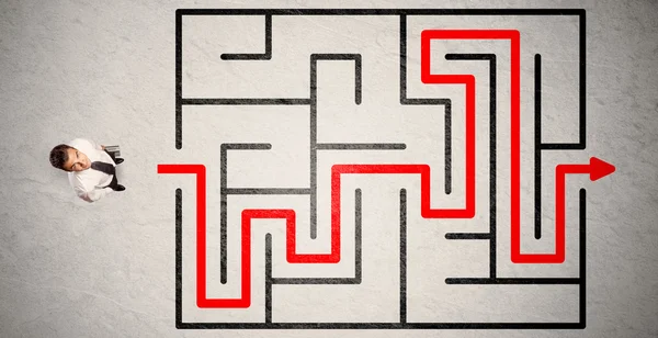 Pengusaha yang hilang menemukan jalan di labirin dengan panah merah — Stok Foto