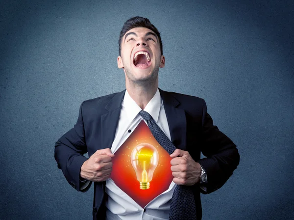 Businessman ripping off shirt and idea light bulb appears — Stock Photo, Image