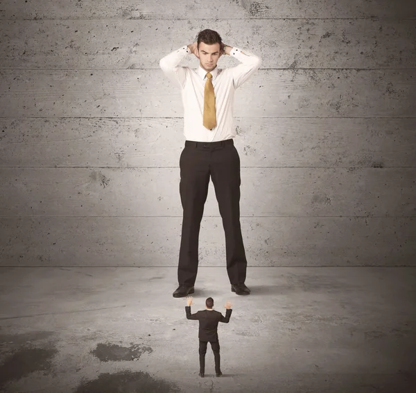 Enorme business guy op zoek naar kleine collega — Stockfoto